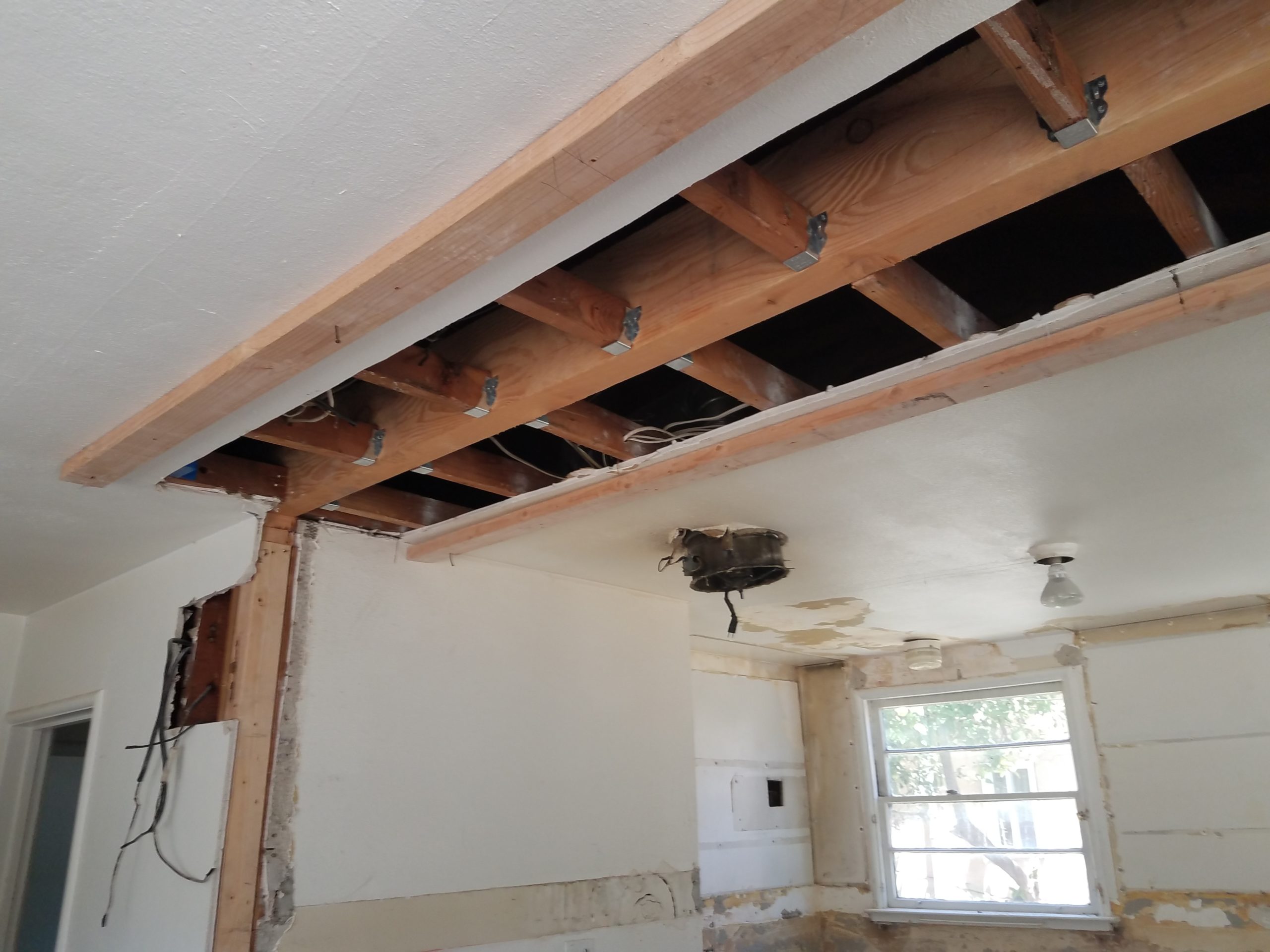Opened drywall ceiling with exposed framing during an interior remodeling project